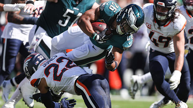 Denver Broncos safety Brandon Jones (22) tackles Philadelphia Eagles running back Saquon Barkley (26).