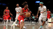 Mar 26, 2025; Brooklyn, New York, USA; Toronto Raptors guard Ja'Kobe Walter (14) drives to the basket against Brooklyn Nets guards D'Angelo Russell (1) and Keon Johnson (45) during the third quarter at Barclays Center. Mandatory Credit: Brad Penner-Imagn Images
