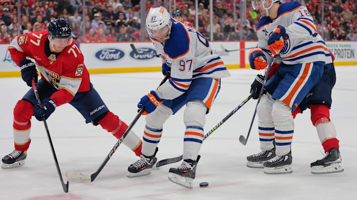 Edmonton Oilers center Connor McDavid moves the puck as Florida Panthers defenseman Niko Mikkola. Edmonton Oilers center Connor McDavid moves the puck as Florida Panthers defenseman Niko Mikkola.