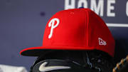 May 26, 2023; Atlanta, Georgia, USA; A detailed view of a Philadelphia Phillies hat and glove on the bench against the Atlanta Braves in the seventh inning at Truist Park. Mandatory Credit: Brett Davis-Imagn Images