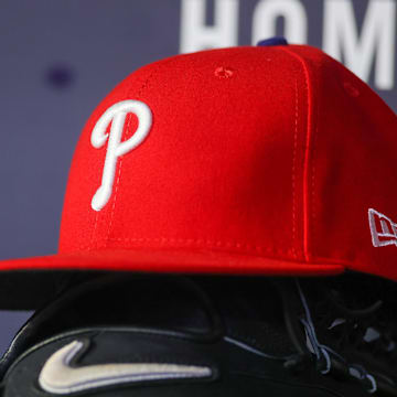 May 26, 2023; Atlanta, Georgia, USA; A detailed view of a Philadelphia Phillies hat and glove on the bench against the Atlanta Braves in the seventh inning at Truist Park. Mandatory Credit: Brett Davis-Imagn Images