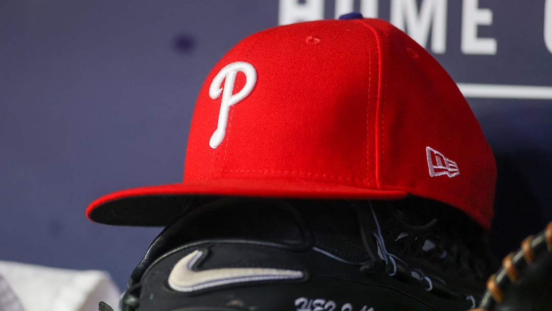 May 26, 2023; Atlanta, Georgia, USA; A detailed view of a Philadelphia Phillies hat and glove on the bench against the Atlanta Braves in the seventh inning at Truist Park. 