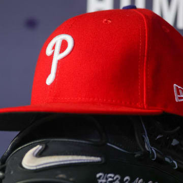 May 26, 2023; Atlanta, Georgia, USA; A detailed view of a Philadelphia Phillies hat and glove on the bench against the Atlanta Braves in the seventh inning at Truist Park.