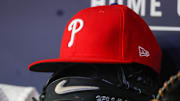 May 26, 2023; Atlanta, Georgia, USA; A detailed view of a Philadelphia Phillies hat and glove on the bench against the Atlanta Braves in the seventh inning at Truist Park. Mandatory Credit: Brett Davis-Imagn Images