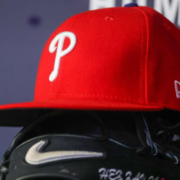 May 26, 2023; Atlanta, Georgia, USA; A detailed view of a Philadelphia Phillies hat and glove on the bench against the Atlanta Braves in the seventh inning at Truist Park.