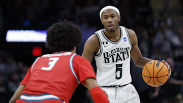 Mar 23, 2025; Cleveland, OH, USA; Michigan State Spartans guard Tre Holloman (5) dribbles defended by New Mexico Lobos guard Tru Washington (3) in the first half during the NCAA Tournament Second Round at Rocket Arena. Mandatory Credit: Rick Osentoski-Imagn Images
