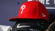 May 26, 2023; Atlanta, Georgia, USA; A detailed view of a Philadelphia Phillies hat and glove on the bench against the Atlanta Braves in the seventh inning at Truist Park.