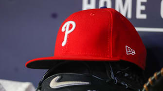 Atlanta, Georgia, USA; A detailed view of a Philadelphia Phillies hat and glove on the bench against the Atlanta Braves in the seventh inning at Truist Park.