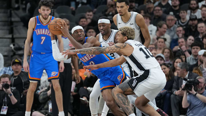 Feb 29, 2024; San Antonio, Texas, USA;  Oklahoma City Thunder guard Shai Gilgeous-Alexander (2) looks to pass against San Antonio Spurs guard Malaki Branham (22) and forward Jeremy Sochan (10) in the first half at Frost Bank Center. Mandatory Credit: Daniel Dunn-Imagn Images