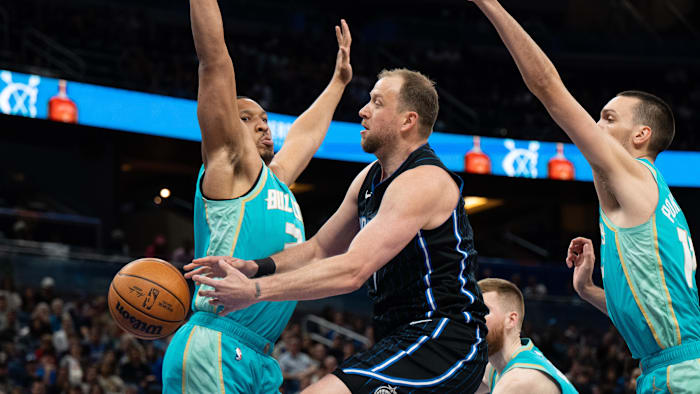 Mar 19, 2024; Orlando, Florida, USA; Orlando Magic forward Joe Ingles (7) passes the ball around Grant Williams of the Charlotte Hornets