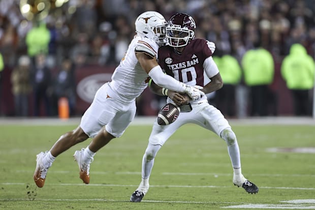 Texas Longhorns linebacker Trey Moore (8) strips the ball away from Texas A&M Aggies quarterback Marcel Reed (10) during the 