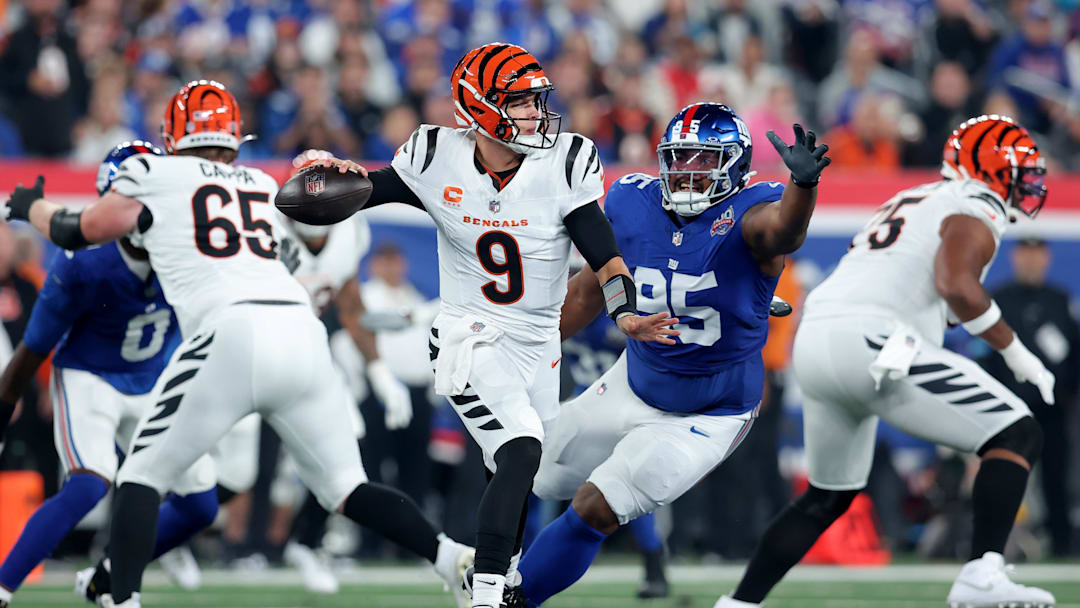 Oct 13, 2024; East Rutherford, New Jersey, USA; Cincinnati Bengals quarterback Joe Burrow (9) looks to pass against New York Giants defensive tackle Jordon Riley (95) during the first quarter at MetLife Stadium. Mandatory Credit: Brad Penner-Imagn Images