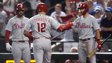 Philadelphia Phillies designated hitter Kyle Schwarber (12) celebrates with shortstop Trea Turner (right) and first baseman Bryce Harper (left) after hitting a home run during the fourth inning against the Arizona Diamondbacks in game four of the NLCS of the 2023 MLB playoffs at Chase Field in Phoenix on Oct. 20, 2023.