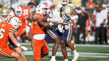 Nov 9, 2024; Atlanta, Georgia, USA; Miami Hurricanes defensive lineman Marquise Lightfoot (12) tackles Georgia Tech Yellow Jackets wide receiver Eric Singleton Jr. (2) in the fourth quarter at Bobby Dodd Stadium at Hyundai Field. Mandatory Credit: Brett Davis-Imagn Images