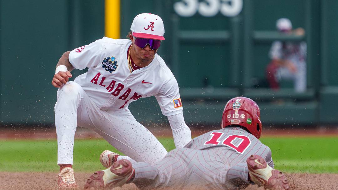 Jun 13, 2026; Omaha, NE, USA; Alabama Crimson Tide shortstop Justin LeBron (1) tags out Oklahoma Sooners left fielder Brendan Brock (10) during the fourth inning at Charles Schwab Field. Mandatory Credit: Dylan Widger-Imagn Images