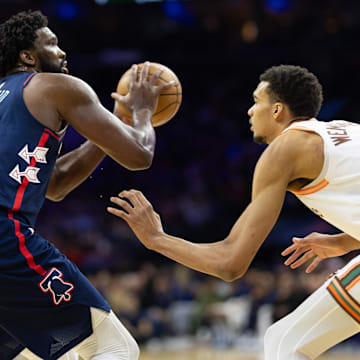 Jan 22, 2024; Philadelphia, Pennsylvania, USA; Philadelphia 76ers center Joel Embiid (21) shoots against San Antonio Spurs center Victor Wembanyama (1) during the second quarter at Wells Fargo Center. Mandatory Credit: Bill Streicher-Imagn Images