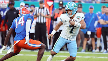 Dec 20, 2024; Tampa, FL, USA; Tulane Green Wave quarterback Ty Thompson (7) runs with the ball as Florida Gators defensive back Jordan Castell (14) tackles during the second quarter at Raymond James Stadium. Mandatory Credit: Kim Klement Neitzel-Imagn Images