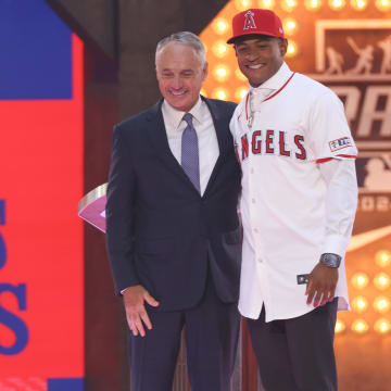 Jul 14, 2024; Ft. Worth, TX, USA;  Christian Moore is congratulated by MLB commissioner Rob Manfred after being selected by the Los Angeles Angels as the eight player taken during the first round of the MLB Draft at Cowtown Coliseum. Mandatory Credit: Kevin Jairaj-USA TODAY Sports