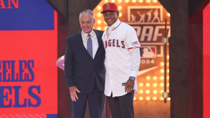 Jul 14, 2024; Ft. Worth, TX, USA;  Christian Moore is congratulated by MLB commissioner Rob Manfred after being selected by the Los Angeles Angels as the eight player taken during the first round of the MLB Draft at Cowtown Coliseum. Mandatory Credit: Kevin Jairaj-USA TODAY Sports