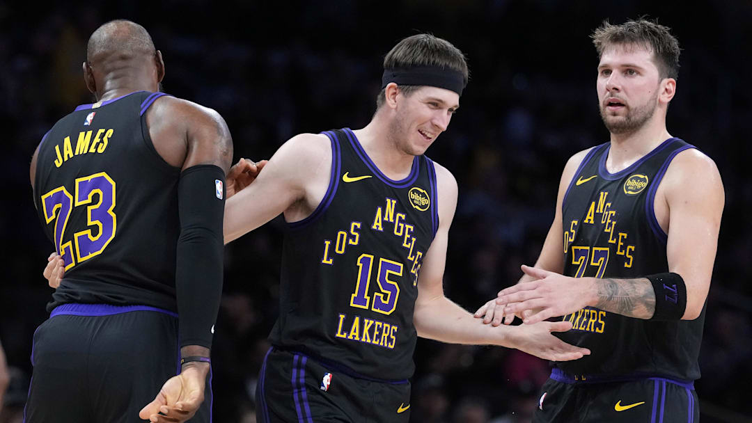 Nov 18, 2025; Los Angeles, California, USA; Los Angeles Lakers guard Austin Reaves (15) is congratulated by forward LeBron James (23) and guard Luka Doncic (77) after a three-point basket in the second quarter at Crypto.com Arena. Mandatory Credit: Kirby Lee-Imagn Images