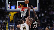 Nov 5, 2025; Denver, Colorado, USA; Miami Heat center Bam Adebayo (13) and Denver Nuggets center Nikola Jokic (15) reach for the rebound in the first quarter at Ball Arena. Mandatory Credit: Ron Chenoy-Imagn Images