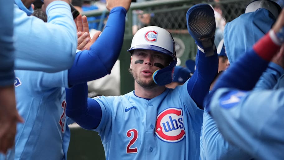 Chicago Cubs second baseman Nico Hoerner (2) is greeted in the dugout