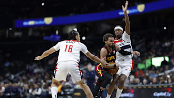 Oct 30, 2024; Washington, District of Columbia, USA; Atlanta Hawks guard Trae Young (11) drives to the basket as Washington Wizards forward Kyshawn George (18) and Wizards guard Bilal Coulibaly (0) defend in the first half at Capital One Arena. Mandatory Credit: Geoff Burke-Imagn Images