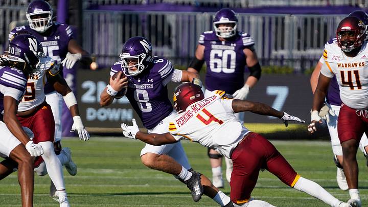Oct 4, 2025; Evanston, Illinois, USA; Northwestern Wildcats quarterback Preston Stone (8) runs the ball as ULM Warhawks cornerback D'Arco Perkins-McAllister (4) tries to tackle him during the first half at Northwestern Medicine Field at Martin Stadium. Mandatory Credit: David Banks-Imagn Images