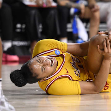 Mar 24, 2025; Los Angeles, California, USA; USC Trojans guard JuJu Watkins (12) grabs her knee after falling to the floor during an NCAA Tournament second round game against the Mississippi State Bulldogs at Galen Center. Mandatory Credit: Robert Hanashiro-Imagn Images