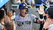  New York Yankees designated hitter Aaron Judge celebrates with teammates in the dugout after hitting a two run home run.