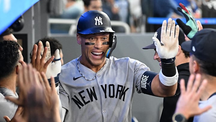  New York Yankees designated hitter Aaron Judge celebrates with teammates in the dugout after hitting a two run home run.