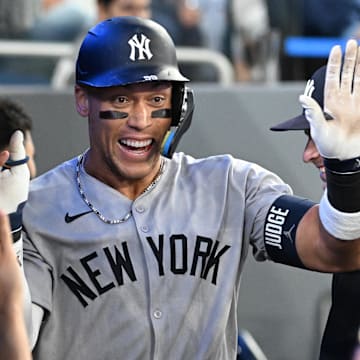 Jul 23, 2025; Toronto, Ontario, CAN;  New York Yankees designated hitter Aaron Judge (99) celebrates with team mates in the dugout after hitting a two run home run against the Toronto Blue Jays in the sixth inning at Rogers Centre. Mandatory Credit: Dan Hamilton-Imagn Images