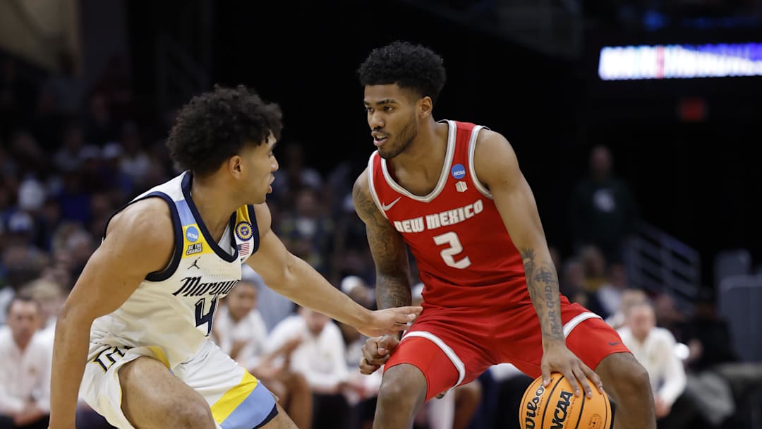 Mar 21, 2025; Cleveland, OH, USA;  New Mexico Lobos guard Donovan Dent (2) plays the ball defended by Marquette Golden Eagles guard Stevie Mitchell (4) in the second half during the NCAA Tournament First Round at Rocket Arena. Mandatory Credit: Rick Osentoski-Imagn Images