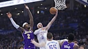 Nov 12, 2025; Oklahoma City, Oklahoma, USA; Oklahoma City Thunder guard Alex Caruso (9) goes up for a basket beside Los Angeles Lakers forward Jarred Vanderbilt (2) during the second quarter at Paycom Center. Mandatory Credit: Alonzo Adams-Imagn Images