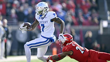 Nov 25, 2023; Louisville, Kentucky, USA;  Kentucky Wildcats wide receiver Barion Brown (7) avoids the tackle of Louisville Cardinals defensive back Devin Neal (27) during the second half at L&N Federal Credit Union Stadium. Kentucky defeated Louisville 38-31. Mandatory Credit: Jamie Rhodes-Imagn Images