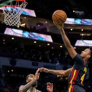 Nov 30, 2024; Charlotte, North Carolina, USA; Atlanta Hawks guard Kobe Bufkin (4) shoots the ball against Charlotte Hornets center Nick Richards (4) during the first quarter at Spectrum Center. Mandatory Credit: Scott Kinser-Imagn Images