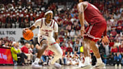 Feb 15, 2025; Tuscaloosa, Alabama, USA; Auburn Tigers guard Denver Jones (2) dribbles the ball against Alabama Crimson Tide guard Chris Youngblood (8) during the first half at Coleman Coliseum.