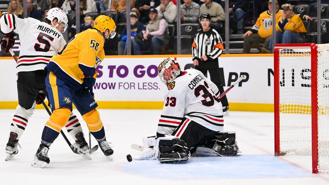 Jan 10, 2026; Nashville, Tennessee, USA;  Chicago Blackhawks goaltender Drew Commesso (33) blocks the shot of Nashville Predators left wing Michael Bunting (58) during the third period at Bridgestone Arena. Mandatory Credit: Steve Roberts-Imagn Images