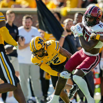 Oct 21, 2023; Columbia, Missouri, USA; South Carolina Gamecocks wide receiver Xavier Legette (17) is tackled by Missouri Tigers defensive back Dreyden Norwood (12) and defensive back Daylan Carnell (13) during the first half at Faurot Field at Memorial Stadium. Mandatory Credit: Jay Biggerstaff-USA TODAY Sports