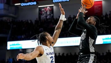 Cincinnati Bearcats guard Day Day Thomas (1) shoots over Xavier Musketeers guard Dante Maddox Jr. (21) in the second half of the 92nd Annual Crosstown Shootout NCAA basketball game between the Cincinnati Bearcats and the Xavier Musketeers at Fifth Third Arena on the UC campus in Cincinnati on Saturday, Dec. 14, 2024. The Bearcats won 68-65.