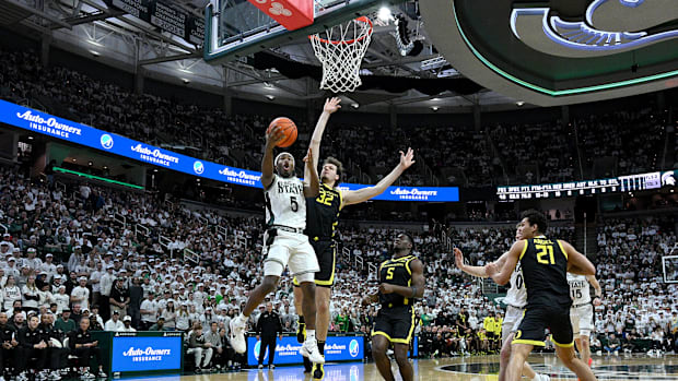 Feb 8, 2025; East Lansing, Michigan, USA; Michigan State Spartans guard Tre Holloman (5) drives past Oregon Ducks center Nate
