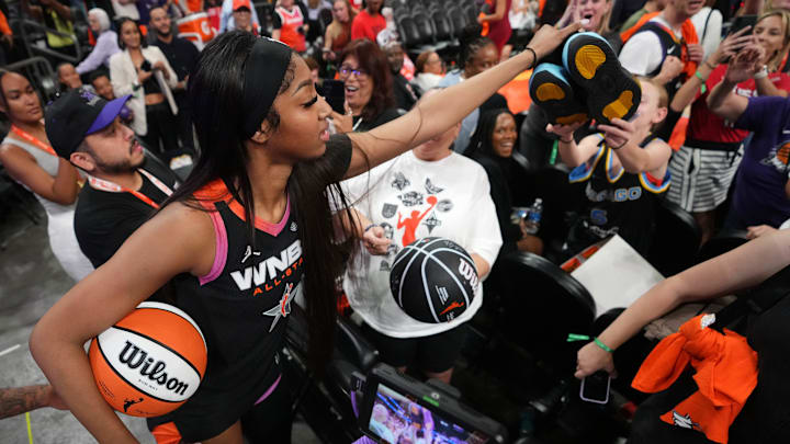 Team WNBA forward Angel Reese (5) hands off her shoes to a young fan after the WNBA All-Star Game at Footprint Center in Phoenix.