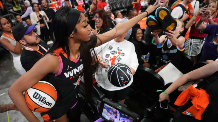 Team WNBA forward Angel Reese (5) hands off her shoes to a young fan after the WNBA All-Star Game at Footprint Center in Phoenix on July 20, 2024.