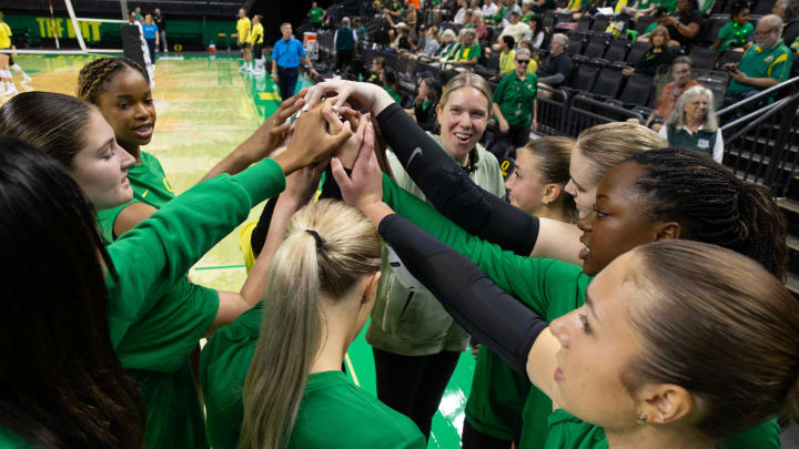 Green team comes together with associate coach Erika Dillard, right, during a scrimmage between teammates for the University of Oregon volleyball team.