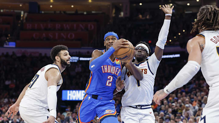 Jan 31, 2024; Oklahoma City, Oklahoma, USA; Oklahoma City Thunder guard Shai Gilgeous-Alexander (2) drives to the basket between Denver Nuggets guard Jamal Murray (27) and guard Reggie Jackson (7) during the second half at Paycom Center. Mandatory Credit: Alonzo Adams-Imagn Images