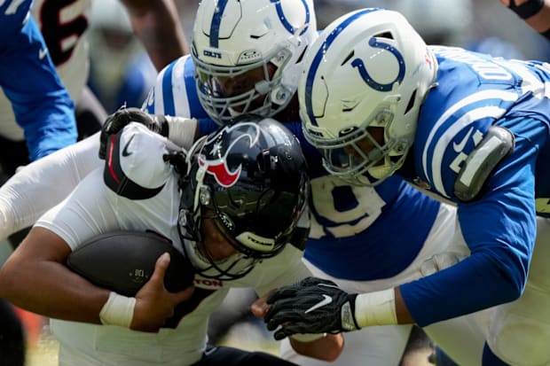 Indianapolis Colts Dayo Odeyingbo and DeForest Buckner sack Houston Texans quarterback C.J. Stroud in blue jerseys.