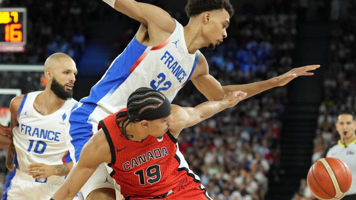 Aug 6, 2024; Paris, France; France power forward Victor Wembanyama (32) reaches for the ball against Canada point guard Andrew Nembhard (19) in the first quarter in a men’s basketball quarterfinal game during the Paris 2024 Olympic Summer Games at Accor Arena. Mandatory Credit: Kyle Terada-USA TODAY Sports