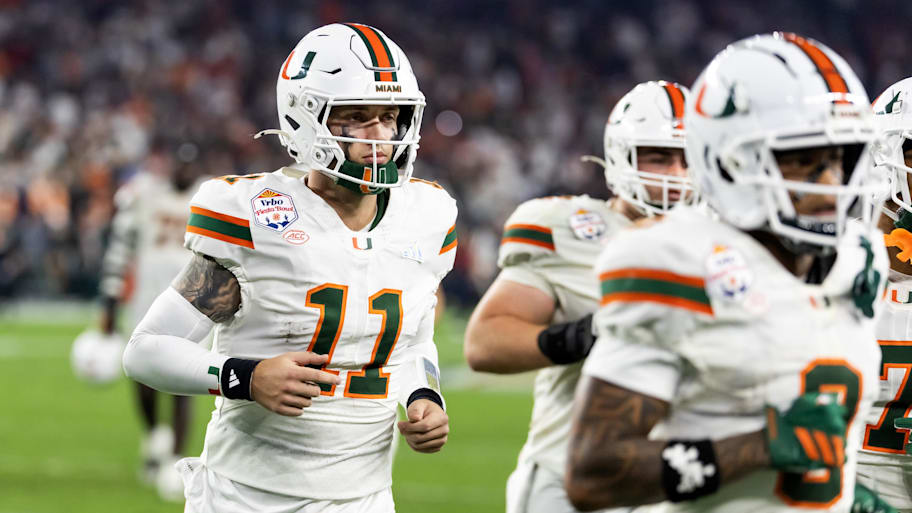 Hurricanes quarterback Carson Beck runs off the field.
