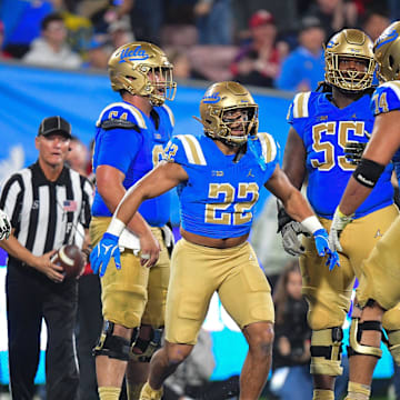Nov 8, 2025; Pasadena, California, USA; UCLA Bruins running back Anthony Frias II (22) celebrates his touchdown scored against the Nebraska Cornhuskers with offensive lineman Julian Armella (74) during the second half at the Rose Bowl. Mandatory Credit: Gary A. Vasquez-Imagn Images