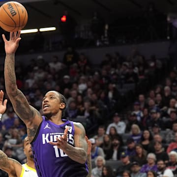 Dec 8, 2024; Sacramento, California, USA; Sacramento Kings forward DeMar DeRozan (front) shoots against Utah Jazz forward John Collins (back) during the second quarter at Golden 1 Center. Mandatory Credit: Darren Yamashita-Imagn Images
